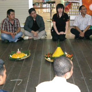 新店舗オープンにともない、閉店後の店で従業員と簡単な食事と祈りの会をした時のもの。食事と祈りの会はインドネシアの伝統的習慣。ターメリックを使って黄色くしたご飯を円錐形に盛った特別な料理で祝う。